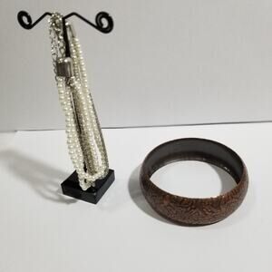 Two bracelets one copper colored bangle one multi chain faux